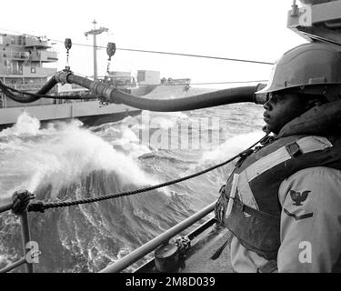 Ein Besatzungsmitglied an Bord des Zerstörers USS PETERSON (DD-969) steht während der Nachfüllarbeiten zwischen DEM PETERSON und dem Flottenöler USNS NEOSHO (T-AO-143) in der Nähe einer Betankungslinie. Die Schiffe sind Teil DER FLOTTE EX 1-90. Betreff Betrieb/Serie: FLOTTE EX 1-90 Land: Atlantik (AOC) Stockfoto