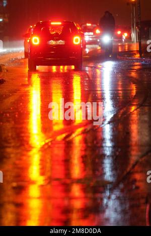 Hamburg, Deutschland. 13. Januar 2023. Lichter glitzern und reflektieren im strömenden Regen auf einer Straße. Kredit: Marcus Brandt/dpa/Alamy Live News Stockfoto