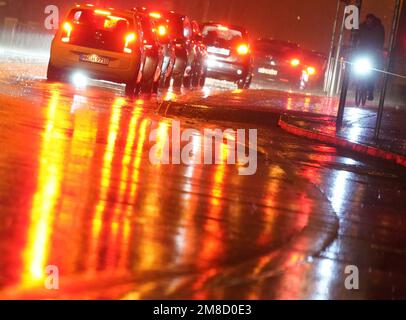Hamburg, Deutschland. 13. Januar 2023. Lichter glitzern und reflektieren im strömenden Regen auf einer Straße. Kredit: Marcus Brandt/dpa/Alamy Live News Stockfoto