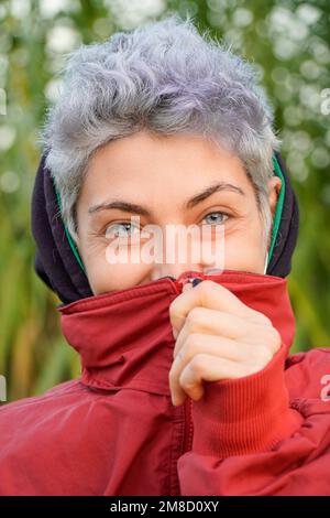 Porträt einer nicht binären Person, die lächelt und in die Kamera schaut. Stockfoto