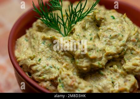 Sprottenpastete mit Spinat und Pfeffer. Sprotte in Öl, dänische Küche. Hintergrund zu Lebensmittelrezepten. Sandwich mit geräucherter Sprotte. Nahaufnahme. Stockfoto