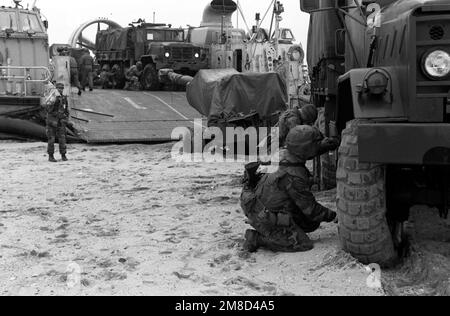 Um zusätzliche Traktion im weichen Sand zu erhalten, senken Marines den Luftdruck in den Reifen ihres M-923 5-Tonnen-Frachtwagens, nachdem sie am D-Day des kombinierten südkoreanischen/US-Übungsteams Spirit '90 vom Luftkissenlandefahrzeug LCAC-18 an Land gefahren sind. Betreff Operation/Serie: TEAMGEIST '90 Basis: Pohang Land: Republik Korea (KOR) Stockfoto