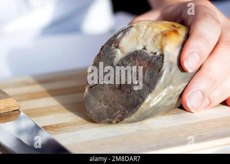 Die traditionelle kasachische Pferdefleischwurst Kazy auf dem hölzernen Schneidebrett aus nächster Nähe. Stockfoto