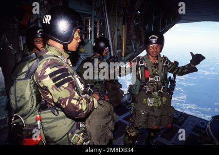 Mitglieder des indonesischen Kampfkontrollteams bereiten sich auf den Sprung aus einem C-130-Transportflugzeug von Hercules während der Phase der Einrichtung der Abwurfzone des Airlift Rodeo '90 vor. Airlift Rodeo ist ein jährlicher Airdrop Wettbewerb, der die Flug- und Bodenfähigkeiten der militärischen Airlift Kommando Flugbesatzungen und ausländischen Teams testet. Betreff Operation/Serie: RODEO '90 Base: Pope Air Force Base State: North Carolina(NC) Country: United States of America(USA) Stockfoto