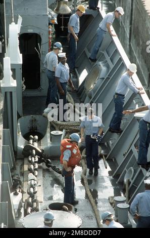 Matrosen, die dem Meer zugeteilt sind, und Ankerteams an Bord des Panzerlandeschiffes USS BARNSTABLE COUNTY (LST-1197) bewachen ihre Stationen, während das Schiff während der jährlichen West Africa Training Cruise am Pier vorbeikommt. Das BARNSTABLE COUNTY wird acht Nationen während der sechswöchigen Kreuzfahrt besuchen, Schulungen mit den Streitkräften der einzelnen Gastländer durchführen, an Projekten für die Beziehungen zu den Gemeinschaften arbeiten und humanitäre Hilfe leisten. Basis: Conakry Land: Guinea (GIN) Stockfoto