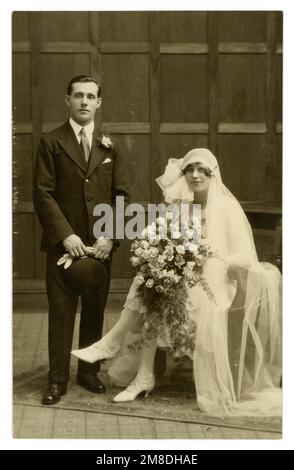 Atemberaubendes Original aus den 1920er Jahren, Flapper-Ära, Hochzeitsfoto, wunderschöne Braut mit langem Schleier, die neben dem gut aussehenden Bräutigam aus dem Jahr 1926 sitzt, Foto von Bradley & Blowers, The Studio, 11 Mersea Road, Colchester, Großbritannien Stockfoto