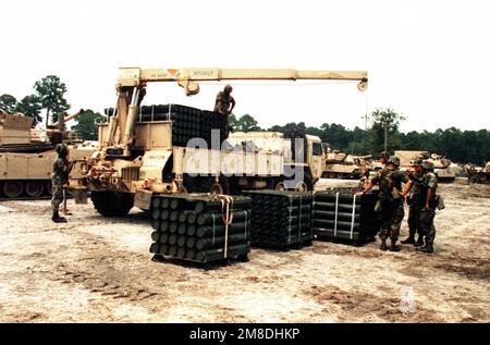 Soldaten vom Hauptquartier Co., 4. Milliarden Dollar, 64. Rüstungen, 24. Inf. Div (Mechanisiert) Verwenden Sie den Ladekran hinten an einem M-977 schweren, erweiterten und taktischen Mobilitätsfahrzeug (HEMTT), um die Munitionspaletten für die M-1 Abrams Hauptkampfpanzer des 1. Bataillons, 64. Rüstung, zu entladen, während sie sich auf den Einsatz nach Saudi-Arabien für die Operation Desert Shield vorbereiten. Betreff Operation/Serie: WÜSTENSCHILDBASIS: Fort Stewart Bundesstaat: Georgia(GA) Land: Vereinigte Staaten von Amerika(USA) Stockfoto