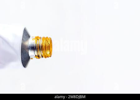 Rohr aus Metall-Acryl mit goldener Farbe zum Zeichnen von Nahaufnahmen auf weißem Hintergrund mit Kopierbereich. Stockfoto