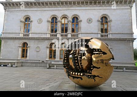 Kugel in der Kugel, spektakuläre Bronze-Globe-Kunstwerke 1982 Geschenk des Bildhauers Arnaldo Pomodoro an das Trinity College, außerhalb der Hauptbibliothek, Dublin, Irland Stockfoto