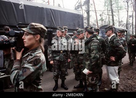 General Crosbie E. Saint, Center, Commander, United States Army Europe und 7. Army, spricht mit einer Gruppe von Offizieren am Ort eines simulierten chemischen Unfalls während der Operation KROKODIL, einer Übung für medizinisches, Dekontaminations- und Chemiereaktionsteam-Personal. Links, SPEZIALIST vierte Klasse (SPC) L. Germaine filmt fast Aktivitäten. Betreff Betrieb/Serie: KROKODIL Land: Deutschland / Deutschland (DEU) Stockfoto