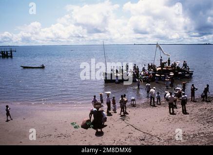 Die Einheimischen waten ins Wasser, um an Bord einer Fähre zu gehen. Lungi befindet sich nördlich von Freetown, Sierra Leone, und ist ein Clearingpunkt für Zivilisten, die im Rahmen der Operation Sharp Edge aus Liberia evakuiert wurden. Betreff Betrieb/Serie: SCHARFE KANTE Basis: Lungi Country: Sierra Leone (SLE) Stockfoto