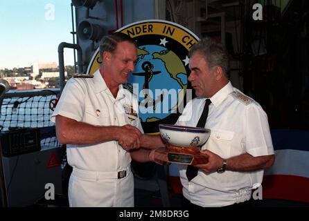 Admiral Charles R. Larson, Left, Oberbefehlshaber der US-Pazifikflotte, überreicht Admiral Gennadi Chvatov, Commander der sowjetischen Pazifikflotte, während einer Zeremonie an Bord des geführten Raketenkreuzers USS PRINCETON (CG 59) eine Schüssel. PRINCETON und die geführte Raketenfregatte USS REUBEN JAMES (FFG 57) sind für einen viertägigen Besuch in Wladiwostok. Basis: Wladiwostok Staat: Sibirien Land: UdSSR (SONNE) Stockfoto