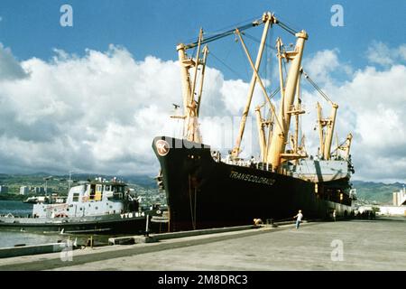 Während der große Hafenschlepper WAXAHATCHIE (YTB-814) gegen seinen Bug drückt, ist das Frachtschiff TRANSCOLORADO (T-AK-2005) an Pier No. Gebunden K-10. Die TRANSCOLORADO ist dem Sealift-Kommando unterstellt. Basis: Marinestützpunkt, Pearl Harbor Bundesstaat: Hawaii (HI) Land: Vereinigte Staaten von Amerika (USA) Stockfoto