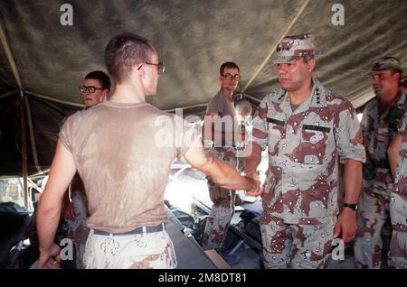GEN. Colin Powell, Vorsitzender der Stabschefs, begrüßt die USA Mitarbeiter der Luftwaffe bei Besuchen militärischer Einrichtungen während der Operation Desert Shield. Betreff Operation/Serie: WÜSTENSCHILD Land: Saudi-Arabien (Sau) Stockfoto