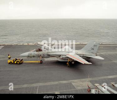 Ein Schlepper MD-3A zieht ein Kampfgeschwader 213 (VF-213) F-14A Tomcat in Richtung Aufzug Nr. 4, nachdem das Flugzeug auf dem Cockpit des nuklearbetriebenen Flugzeugträgers USS ABRAHAM LINCOLN (CVN-72) landet. Der LINCOLN ist während seiner Umfahrung durch Südamerika unterwegs. Land: Pazifik (POC) Stockfoto