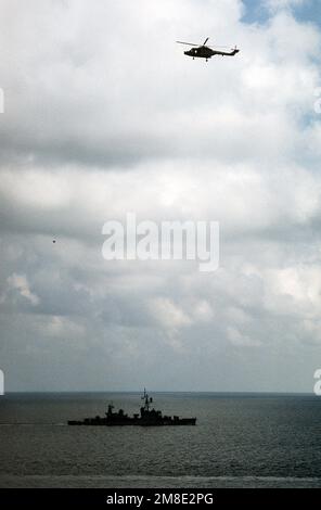 Ein Lynx-Helikopter der Royal Navy fliegt über dem griechischen Zerstörer HS Kriezis (DD-217), da die Mitglieder der Marine Bereitschaftsdienste Mittelmeer Task Force 432 an der Übung Deterrent Force 2/90, einem Teil der Operation Desert Shield, teilnehmen. Betrifft Operation/Serie: WÜSTENSCHILDLAND: Mittelmeer (MED) Stockfoto