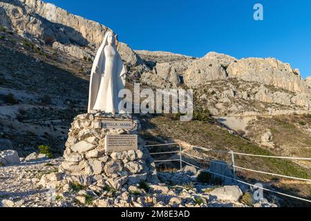 Stella Maris Aussichtspunkt und Skulptur. Mädchen betet in der Nähe der Stella Maris (der Stern des Meeres). Jesus' Mutterskulptur über dem Meer in Kroatien. Stockfoto