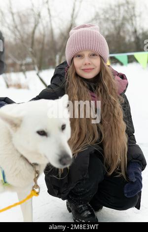 Outdoor-Saison Freundschaft Husky Winter Woman erwachsenes junges Mädchen Tier Schneehund Tierpark Stockfoto