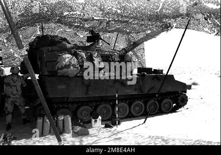 Ein Crewman übergibt ein 155mm-Projektil in eine R-Batterie, 5. Bataillon, 11. Marines Regiment, 1. Marine Division, 155mm M-109A1, selbstfahrender Haubitzer während der Operation Desert Shield. Betreff Operation/Serie: WÜSTENSCHILD Land: Saudi-Arabien (Sau) Stockfoto