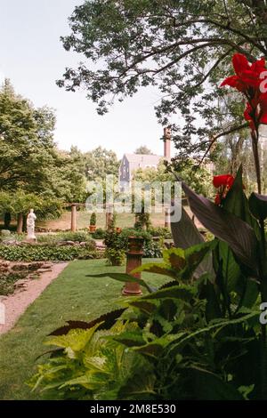 Eine weiße Statue einer Göttin steht in einem italienischen Garten mit dem Haus im Hintergrund auf dem Codman Estate. Lincoln, Massachusetts. Das Bild war ca. Stockfoto