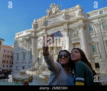 Rom, Italien, Europa: Zwei Touristen fotografieren sich vor der Kulisse des Trevi-Brunnens Stockfoto