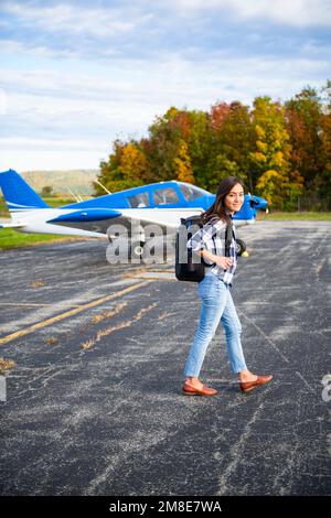 Junge BIPOC weibliche Pilotin bereitet sich auf die Reise mit einem kleinen Flugzeug vor Stockfoto