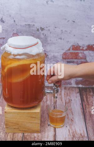 Öffnen des Zapfens einer Flasche fermentierten Kombucha-Tees Stockfoto