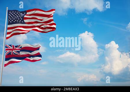 Große offizielle US-Flagge mit einer kleineren Flagge des Bundesstaats Hawaii, USA, im wolkigen Hintergrund. Patriotisches Konzept der Vereinigten Staaten von Amerika. Speicherplatz kopieren für Stockfoto