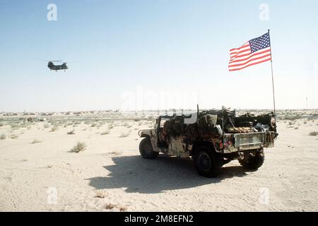 Die amerikanische Flagge fliegt von einem M998 High-Mobility Multipurpose Wheeled Vehicle (HMMWV), das während der Operation Desert Shield in einem Basislager mit Vorräten beladen ist. Betreff Operation/Serie: WÜSTENSCHILD Land: Saudi-Arabien (Sau) Stockfoto