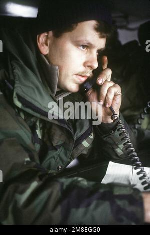 Ein FAC (Forward Air Controller) sitzt in einem Fahrzeug, während er mit dem Piloten eines ankommenden Flugzeugs während der gemeinsamen Bereitschaftsübung Arctic Warrior '91 kommuniziert. Betreff Operation/Serie: ARKTIS-KRIEGER '91 Basis: Fort Greely Bundesstaat: Alaska (AK) Land: Vereinigte Staaten von Amerika (USA) Stockfoto