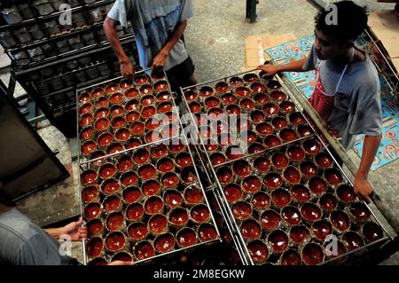 Depok, WEST JAVA, Indonesien. 12. Januar 2023. Arbeiter bereiten „Kue Keranjang“ (Korbkuchen) in einem traditionellen Kuchenmacher zu, der seit 35 Jahren in Depok, West Java, Indonesien, am 13. Januar 2023 in Betrieb ist. Klebriger Reis und Zucker und hat eine kaute und klebrige Konsistenz, die 15 Stunden gekocht wird. Vor den chinesischen Neujahrsfeiern stiegen die Verkäufe dieser Kuchen, insbesondere in der chinesischen Gemeinde in Indonesien. (Kreditbild: © Dasril Roszandi/ZUMA Press Wire) NUR REDAKTIONELLE VERWENDUNG! Nicht für den kommerziellen GEBRAUCH! Stockfoto