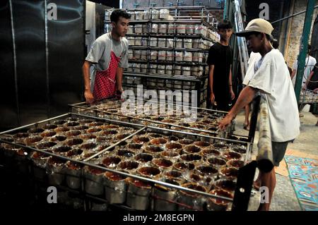 Depok, WEST JAVA, Indonesien. 12. Januar 2023. Arbeiter bereiten „Kue Keranjang“ (Korbkuchen) in einem traditionellen Kuchenmacher zu, der seit 35 Jahren in Depok, West Java, Indonesien, am 13. Januar 2023 in Betrieb ist. Klebriger Reis und Zucker und hat eine kaute und klebrige Konsistenz, die 15 Stunden gekocht wird. Vor den chinesischen Neujahrsfeiern stiegen die Verkäufe dieser Kuchen, insbesondere in der chinesischen Gemeinde in Indonesien. (Kreditbild: © Dasril Roszandi/ZUMA Press Wire) NUR REDAKTIONELLE VERWENDUNG! Nicht für den kommerziellen GEBRAUCH! Stockfoto