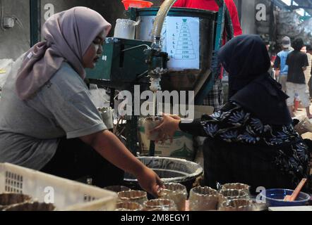 Depok, WEST JAVA, Indonesien. 12. Januar 2023. Arbeiter bereiten „Kue Keranjang“ (Korbkuchen) in einem traditionellen Kuchenmacher zu, der seit 35 Jahren in Depok, West Java, Indonesien, am 13. Januar 2023 in Betrieb ist. Klebriger Reis und Zucker und hat eine kaute und klebrige Konsistenz, die 15 Stunden gekocht wird. Vor den chinesischen Neujahrsfeiern stiegen die Verkäufe dieser Kuchen, insbesondere in der chinesischen Gemeinde in Indonesien. (Kreditbild: © Dasril Roszandi/ZUMA Press Wire) NUR REDAKTIONELLE VERWENDUNG! Nicht für den kommerziellen GEBRAUCH! Stockfoto