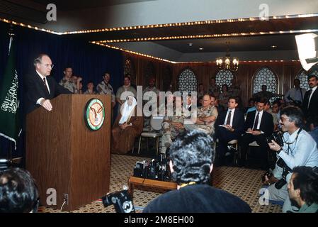 Verteidigungsminister Richard Cheney beantwortet Fragen aus den Medien, während er an einer Pressekonferenz teilnimmt, die von US-amerikanischen und Saudi-arabischen Beamten während der Operation Desert Storm abgehalten wurde. Im Hintergrund sitzen: GEN. Colin Powell, Vorsitzender, Stabschefs; GEN. Norman Schwarzkopf, Oberbefehlshaber, USA Zentralkommando und Paul D. Wolfowitz, stellvertretender Verteidigungsminister für Politik. Betreff Operation/Serie: WÜSTENSTURM Land: Saudi-Arabien (Sau) Stockfoto