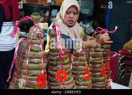 Depok, WEST JAVA, Indonesien. 12. Januar 2023. Arbeiter bereiten „Kue Keranjang“ (Korbkuchen) in einem traditionellen Kuchenmacher zu, der seit 35 Jahren in Depok, West Java, Indonesien, am 13. Januar 2023 in Betrieb ist. Klebriger Reis und Zucker und hat eine kaute und klebrige Konsistenz, die 15 Stunden gekocht wird. Vor den chinesischen Neujahrsfeiern stiegen die Verkäufe dieser Kuchen, insbesondere in der chinesischen Gemeinde in Indonesien. (Kreditbild: © Dasril Roszandi/ZUMA Press Wire) NUR REDAKTIONELLE VERWENDUNG! Nicht für den kommerziellen GEBRAUCH! Stockfoto