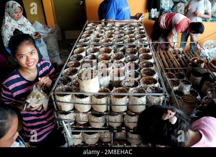 Depok, WEST JAVA, Indonesien. 12. Januar 2023. Arbeiter bereiten „Kue Keranjang“ (Korbkuchen) in einem traditionellen Kuchenmacher zu, der seit 35 Jahren in Depok, West Java, Indonesien, am 13. Januar 2023 in Betrieb ist. Klebriger Reis und Zucker und hat eine kaute und klebrige Konsistenz, die 15 Stunden gekocht wird. Vor den chinesischen Neujahrsfeiern stiegen die Verkäufe dieser Kuchen, insbesondere in der chinesischen Gemeinde in Indonesien. (Kreditbild: © Dasril Roszandi/ZUMA Press Wire) NUR REDAKTIONELLE VERWENDUNG! Nicht für den kommerziellen GEBRAUCH! Stockfoto