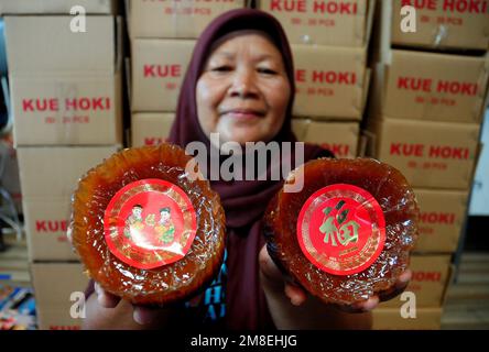 Depok, WEST JAVA, Indonesien. 12. Januar 2023. Arbeiter bereiten „Kue Keranjang“ (Korbkuchen) in einem traditionellen Kuchenmacher zu, der seit 35 Jahren in Depok, West Java, Indonesien, am 13. Januar 2023 in Betrieb ist. Klebriger Reis und Zucker und hat eine kaute und klebrige Konsistenz, die 15 Stunden gekocht wird. Vor den chinesischen Neujahrsfeiern stiegen die Verkäufe dieser Kuchen, insbesondere in der chinesischen Gemeinde in Indonesien. (Kreditbild: © Dasril Roszandi/ZUMA Press Wire) NUR REDAKTIONELLE VERWENDUNG! Nicht für den kommerziellen GEBRAUCH! Stockfoto