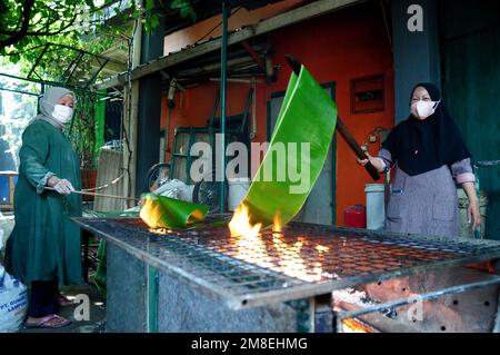 Depok, WEST JAVA, Indonesien. 12. Januar 2023. Arbeiter bereiten „Kue Keranjang“ (Korbkuchen) in einem traditionellen Kuchenmacher zu, der seit 35 Jahren in Depok, West Java, Indonesien, am 13. Januar 2023 in Betrieb ist. Klebriger Reis und Zucker und hat eine kaute und klebrige Konsistenz, die 15 Stunden gekocht wird. Vor den chinesischen Neujahrsfeiern stiegen die Verkäufe dieser Kuchen, insbesondere in der chinesischen Gemeinde in Indonesien. (Kreditbild: © Dasril Roszandi/ZUMA Press Wire) NUR REDAKTIONELLE VERWENDUNG! Nicht für den kommerziellen GEBRAUCH! Stockfoto