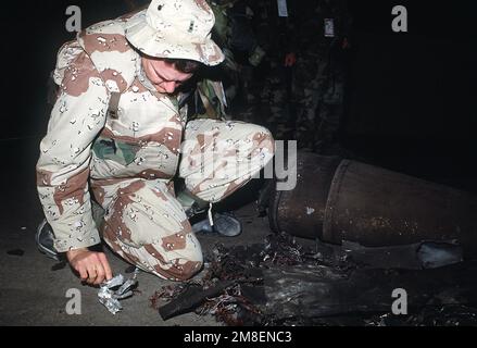 CHIEF Warrant Officer 2. Klasse David Stuart, Patriot Btry., 3. Milliarden Dollar, 43. Air Defense Arty., inspiziert Teile einer irakischen Scud-Rakete, die während der Operation Desert Storm von einer abfangenden Patriot-Rakete abgeschossen wurde. Betreff Operation/Serie: WÜSTENSTURM Land: Saudi-Arabien (Sau) Stockfoto