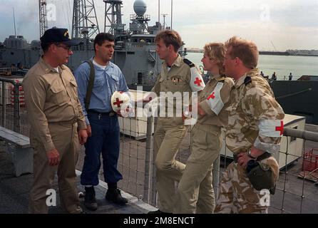 SENIOR CHIEF Hospital Corpsman W. C. Tutcher, Left, und Hospital Corpsman 3. Klasse Frank J. Chaves, Zweiter von links, vergleichen Sie Notizen mit niederländischem medizinischem Personal auf dem Deck des niederländischen Schnellkampfschiffs HNLMS ZUIDERKRUIS (A832), während das Schiff während der Operation Desert Storm im Hafen liegt. Tutcher und Chaves dienen an Bord der geführten Raketenfregatte USS MCINERNEY (FFG-8). Betreff Operation/Serie: WÜSTENSTURM Land: Bahrain (BHR) Stockfoto