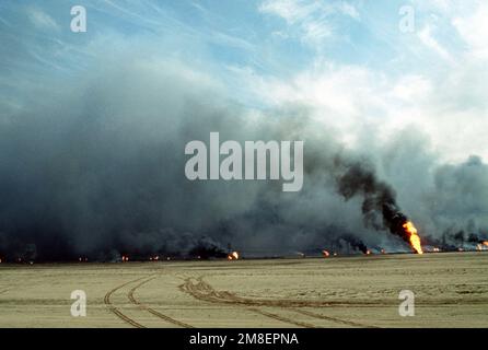 Ölquellen verbrennen außer Kontrolle und verdunkeln den Himmel mit Rauch, nachdem sie durch den Rückzug der irakischen Streitkräfte während der Operation Desert Storm in Brand gesetzt wurden. Betreff Betrieb/Serie: WÜSTENSTURM Land: Kuwait(KWT) Stockfoto