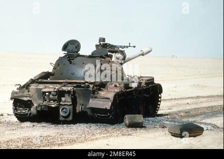 Ein zerstörter irakischer T-55-Hauptkampfpanzer steht auf einem Schlachtfeld, nachdem er während der Operation Desert Storm von alliierten Streitkräften zerstört wurde. Betreff Betrieb/Serie: WÜSTENSTURM Land: Kuwait(KWT) Stockfoto