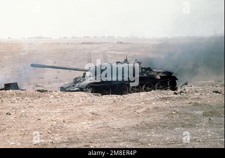 Ein zerstörter irakischer T-55-Hauptkampfpanzer steht auf einem Schlachtfeld, nachdem er während der Operation Desert Storm von alliierten Streitkräften zerstört wurde. Betreff Betrieb/Serie: WÜSTENSTURM Land: Kuwait(KWT) Stockfoto