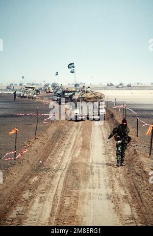 Eine Säule von M-113-gepanzerten Personalträgern und anderen Militärfahrzeugen der Königlichen Saudi-Liga reist entlang eines Kanals, der während der Operation Desert Storm von Minen freigehalten wurde. Betroffene Operation/Serie: WÜSTENSTURM Land: Unbekannt Stockfoto