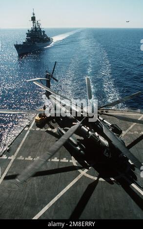 Besatzungsmitglieder an Bord des vom militärischen Sealift-Kommando betriebenen Flottenölers USNS JOSHUA HUMPHREYS (T-AO-188) entladen nach der Operation Desert Storm einen CH-53E Super-Hallion-Hubschrauber, während sich der gesteuerte Raketenzerstörer USS WILLIAM V. PRATT (DDG-44) von hinten nähert. Der PRATT führt Missionen der Maritime Interdiction Force durch, um die UN-Handelssanktionen gegen den Irak zu unterstützen. Betreff Operation/Serie: WÜSTENSTURMLAND: Rotes Meer Stockfoto