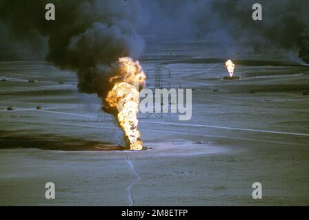 Ölquellen verbrennen außer Kontrolle und verdunkeln den Himmel mit Rauch, nachdem sie durch den Rückzug der irakischen Streitkräfte während der Operation Desert Storm in Brand gesetzt wurden. Betreff Betrieb/Serie: WÜSTENSTURM Land: Kuwait(KWT) Stockfoto