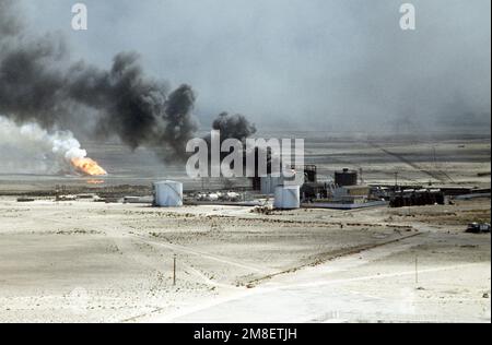 Ölquellen verbrennen außer Kontrolle und verdunkeln den Himmel mit Rauch, nachdem sie durch den Rückzug der irakischen Streitkräfte während der Operation Desert Storm in Brand gesetzt wurden. Betreff Betrieb/Serie: WÜSTENSTURM Land: Kuwait(KWT) Stockfoto