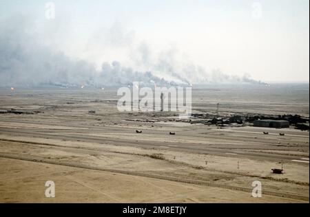 Ölquellen verbrennen außer Kontrolle und verdunkeln den Himmel mit Rauch, nachdem sie durch den Rückzug der irakischen Streitkräfte während der Operation Desert Storm in Brand gesetzt wurden. Betreff Betrieb/Serie: WÜSTENSTURM Land: Kuwait(KWT) Stockfoto