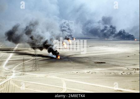 Ölquellen verbrennen außer Kontrolle und verdunkeln den Himmel mit Rauch, nachdem sie durch den Rückzug der irakischen Streitkräfte während der Operation Desert Storm in Brand gesetzt wurden. Betreff Betrieb/Serie: WÜSTENSTURM Land: Kuwait(KWT) Stockfoto