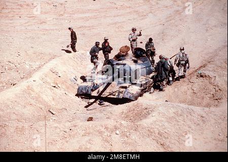 Soldaten untersuchen einen irakischen T-55-Hauptschlachtpanzer, der von der 6. Leichten bewaffneten Division der Franzosen während der Operation Desert Storm zerstört wurde. Betreff Operation/Serie: WÜSTENSTURM Land: Irak (IRQ) Stockfoto